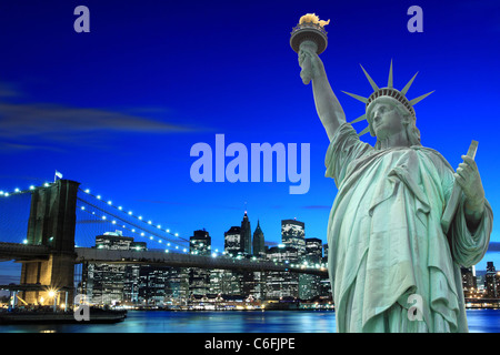 Manhattan Skyline, Brooklyn Bridge and The Statue of Liberty at Night Lights, New York City Stock Photo