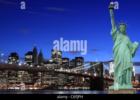 Manhattan Skyline, Brooklyn Bridge and The Statue of Liberty at Night Lights, New York City Stock Photo