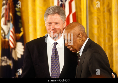 President Bill Clinton assists Herman Shaw, a survivor of the Tuskegee ...