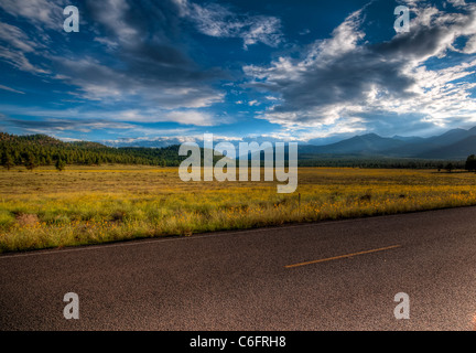 Tar road running through Sunset Crater National Monument in northern Arizona. Sunset. Stock Photo