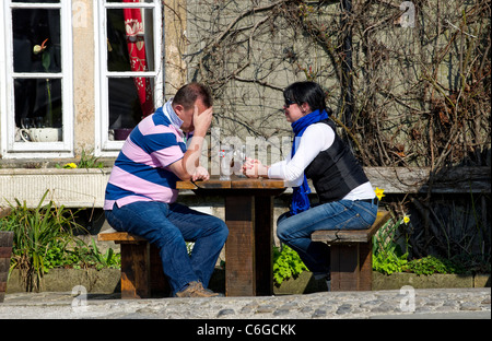 Male and female couple sitting at a table outside a public house Stock Photo