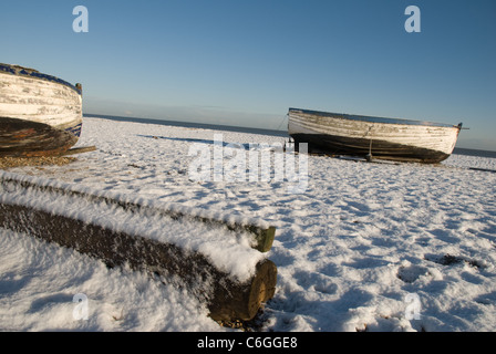 Fishing Boats on Aldeburgh Beach covered in snow. Stock Photo