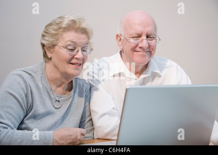Mature couple smiling and enjoying using a laptop computer Stock Photo