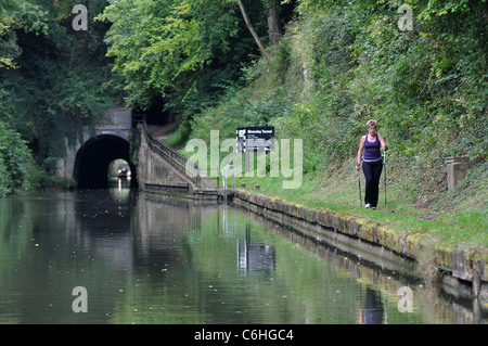 A woman Nordic walking on Grand Union Canal towpath near Shrewley Tunnel, Warwickshire, UK Stock Photo