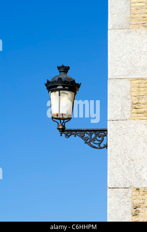 Old cast iron streetlight on a wall Stock Photo