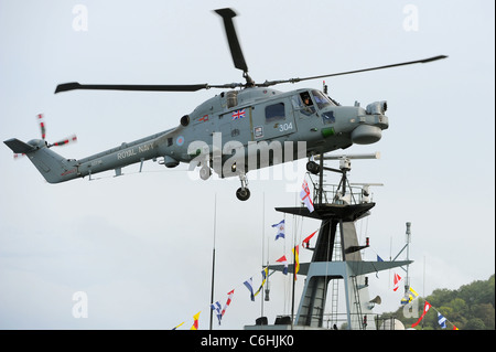 A Royal Navy Lynx helicopter maneuvering in the sky above the River Dart in Dartmouth during the Dartmouth Royal Regatta Stock Photo