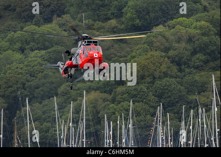 A Royal Navy Sea King rescue helicopter performs a mock rescue over the River Dart, Dartmouth. Stock Photo