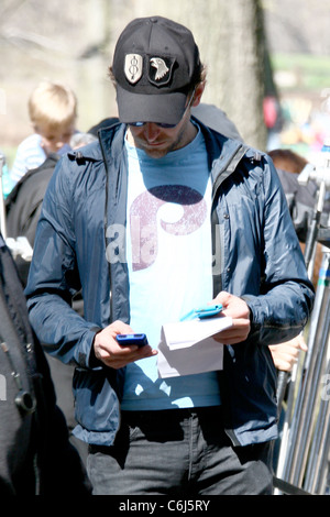 Bradley Cooper texting on his cell phone while on the film set for his new movie 'The Dark Fields' shooting on location near Stock Photo