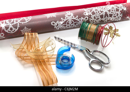 Christmas wrapping paper with scissors ribbon and tape on a white background Stock Photo