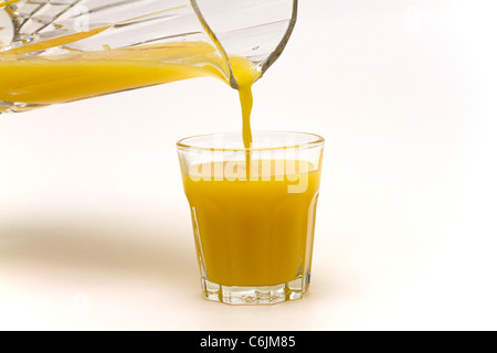 Pouring a glass of fresh orange juice on a white background Stock Photo