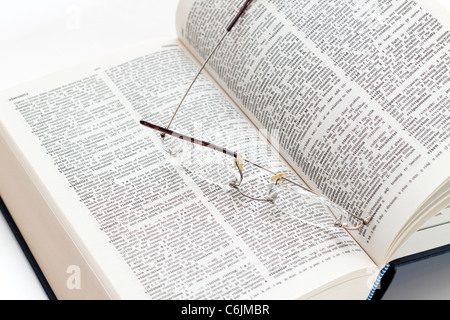 A pair of reading glasses on an open dictionary Stock Photo