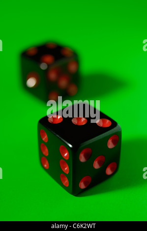 Pair of black dice isolated on green background Stock Photo