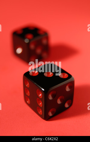 Pair of black dice isolated on red background Stock Photo