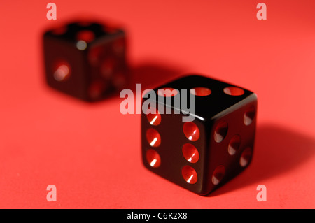 Pair of black dice isolated on red background Stock Photo