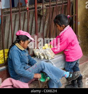 Two girls at a market stall, Sacred Valley, Cusco Region, Peru Stock Photo