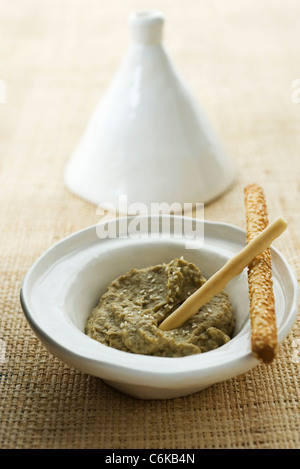 Roasted eggplant dip served in tagine dish with breadsticks Stock Photo