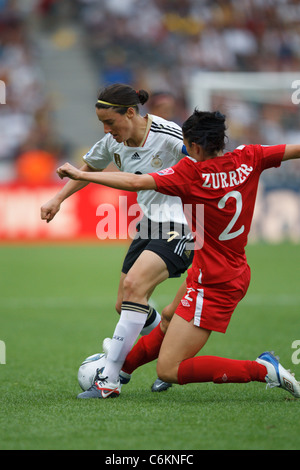 Emily Zurrer of Canada (r) tries to tackle the ball from German's Birgit Prinz (l) during the opening match of the 2011 W. Cup. Stock Photo