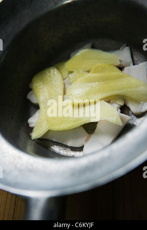 Thin-sliced galangal and bacon in pan Stock Photo