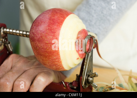 Peeling apple with apple peeler Stock Photo