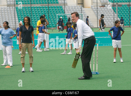 British Prime Minister David Cameron, with Dame Kelly Holmes, playing cricket, at the National Stadium in New Delhi, India, Stock Photo