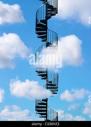 metal spiral staircase rising through bright blue sky with puffy white clouds Stock Photo