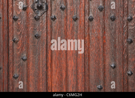 Closeup of a traditional wooden door with cast iron studs Stock Photo