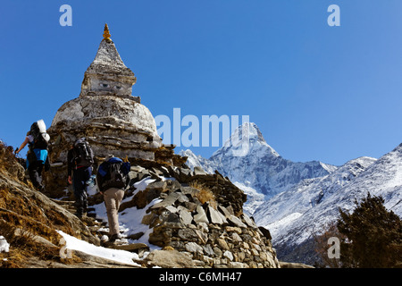 Trekkers walking past a stupa with the mountain Ama Dablam in the background, Everest Region, Nepal Stock Photo