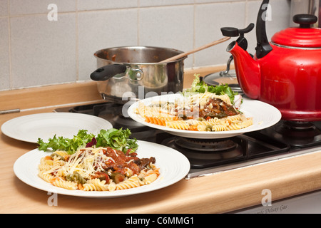 Everyday image of plates of freshly prepared food on a gas hob in a domestic kitchen Stock Photo