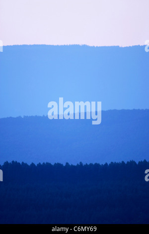 An abstract of forested mountain slopes in shades of blue Stock Photo
