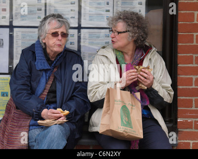 Two old women eating Cornish pasties, Cornwall, UK Stock Photo
