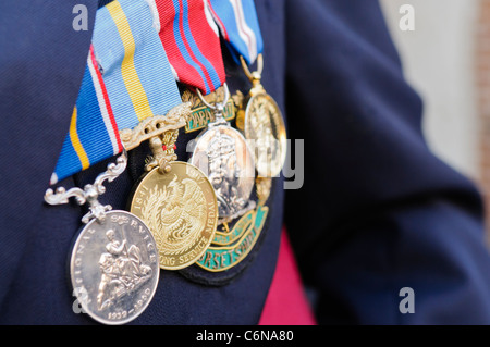 Medals on a war veteran wearing a National Service 1936-1960, Hong Kong Long Service Medal, 1953 Coronation Medal and a 2002 Golden Jubilee medal Stock Photo