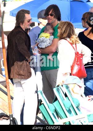 Jim Carrey holding his grandson Jackson Santana while talking to Gary Oldman on Malibu Beach Malibu, California - 04.07.10 Stock Photo