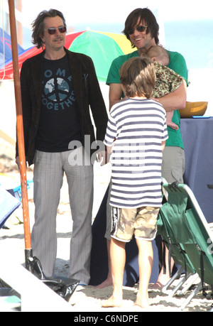 Jim Carrey holding his grandson Jackson Santana while talking to Gary Oldman on Malibu Beach Malibu, California - 04.07.10 Stock Photo