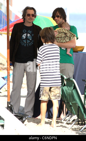 Jim Carrey holding his grandson Jackson Santana while talking to Gary Oldman on Malibu Beach Malibu, California - 04.07.10 Stock Photo