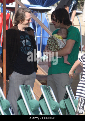 Jim Carrey holding his grandson Jackson Santana while talking to Gary Oldman on Malibu Beach Malibu, California - 04.07.10 Stock Photo