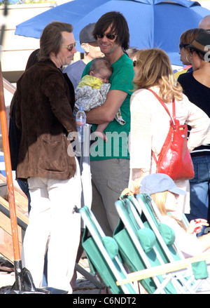 Jim Carrey holding his grandson Jackson Santana while talking to Gary Oldman on Malibu Beach Malibu, California - 04.07.10 Stock Photo