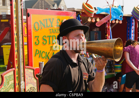 Man using an old fashioned brass loudhailer at a Victorian themed funfair Stock Photo