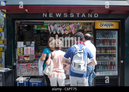 Clients wait in line at a Newsstand shop in the New York City borough of Manhattan, NY. Stock Photo