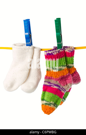 four baby socks on yellow clothesline with clothespin in white background Stock Photo