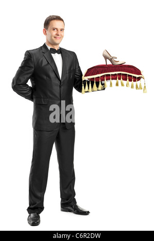 Full length portrait of a man in suit holding a pillow with a hoe on it Stock Photo