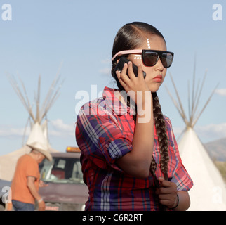 Young Native American woman in Ft Hall, Idaho, using a mobile phone before taking part in a powwow. Stock Photo