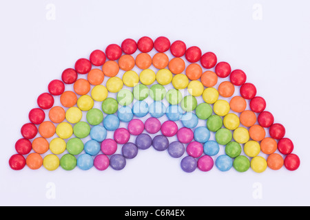 Rainbow smartie pattern on a white background. Stock Photo