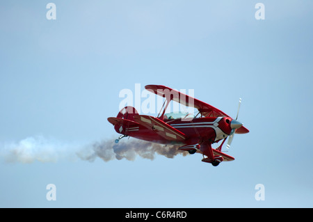 Red plane looping in a blue sky. Close up