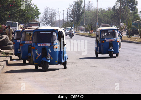 Street crowded with traffic and blue bajaj taxis Stock Photo