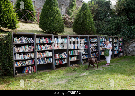 A woman browsing at an honesty bookshop in the grounds of Hay Castle in Hay-On-Wye, UK Stock Photo