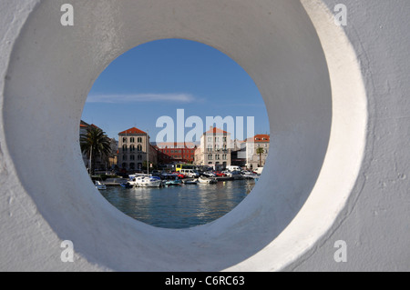 View on harbor through a hole in a wall Stock Photo