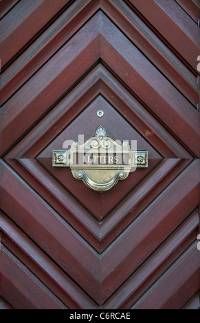 Old brass letterbox on an unusual wooden door in Edinburgh, Scotland. Stock Photo