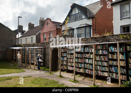 Two people browsing at an honesty bookshop in the grounds of Hay Castle in Hay-On-Wye, UK Stock Photo