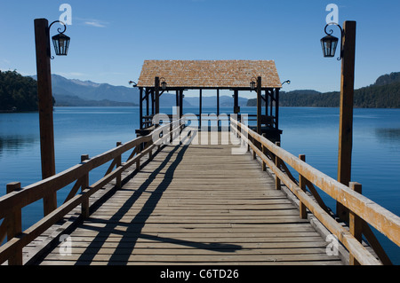 Nahuel Huapi Lake in Argentina on a day of faultless blue sky and matching flat calm blue water seen over a deserted jetty. Stock Photo