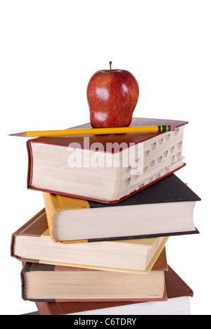 Stack of colorful hardbound books stacked vertically with a red apple and yellow pencil on the top book. Stock Photo